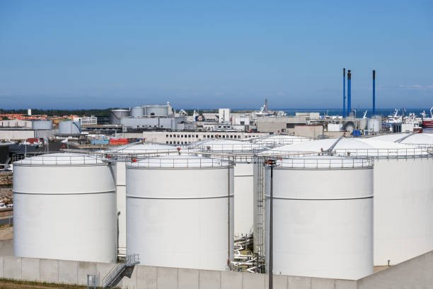 White storage tanks, pipelines and vessels at a coastal terminal